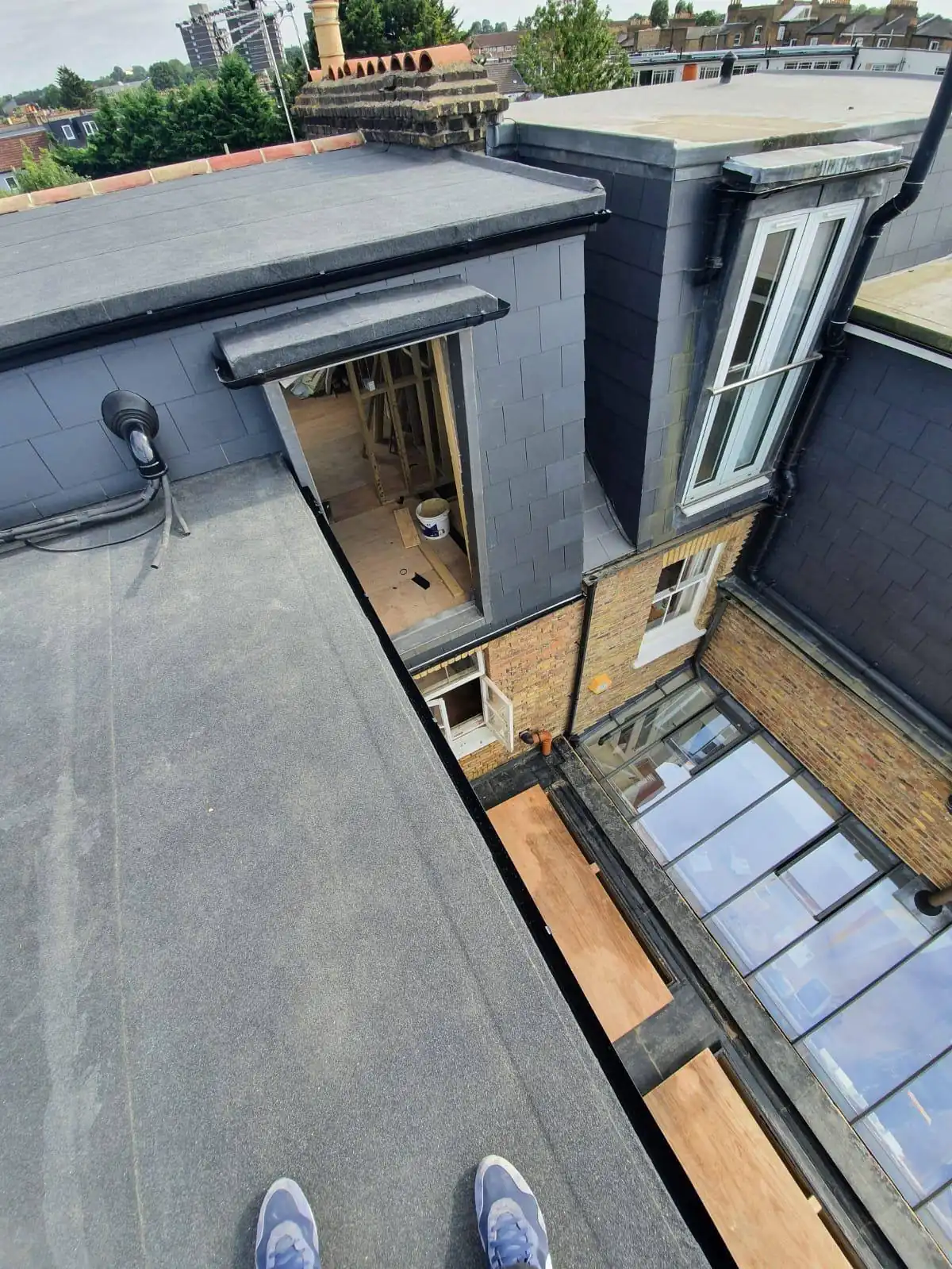 Standing on a flat roof during a roof check, terraces beyond