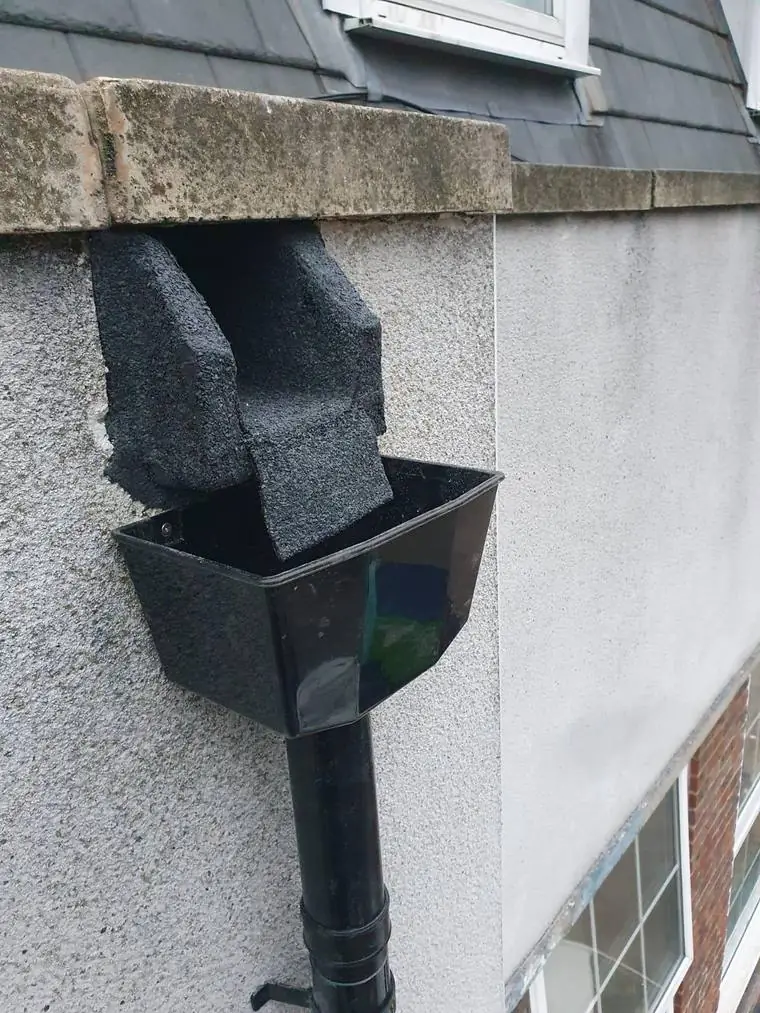 A new hopper and downpipe on a rendered wall